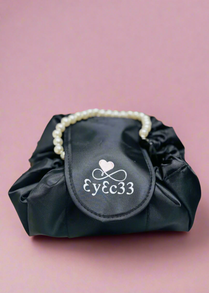 Black bag with pearl handle and logo on a pink background