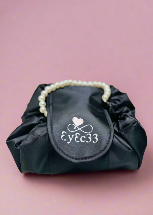 Black bag with pearl handle and logo on a pink background