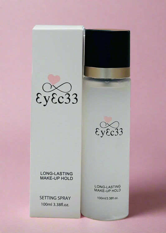 Eyec33 makeup setting spray bottle and packaging on a pink background